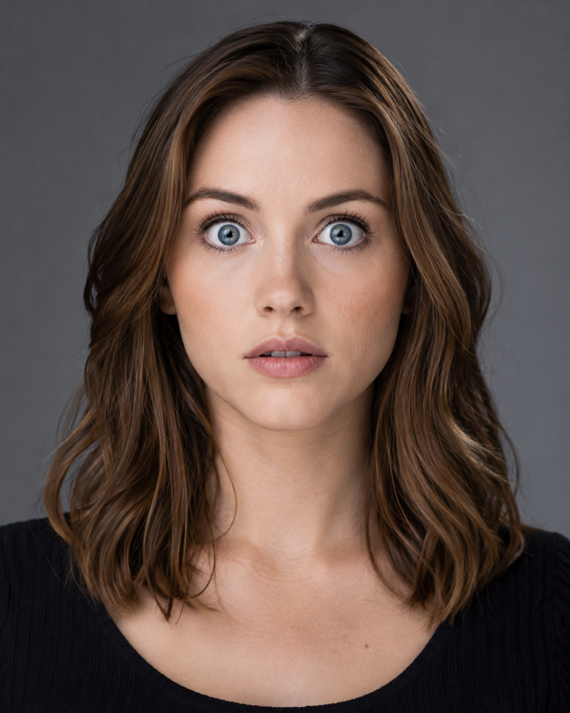 Real actor (site-owned), tight head-and-shoulders crop, eyes wide open and fully exposed, whites visible above and below the iris, neutral expression. Should read as slightly startled or uncertain — the deer-in-headlights look Hurley describes. Same light, same frame as its pair.