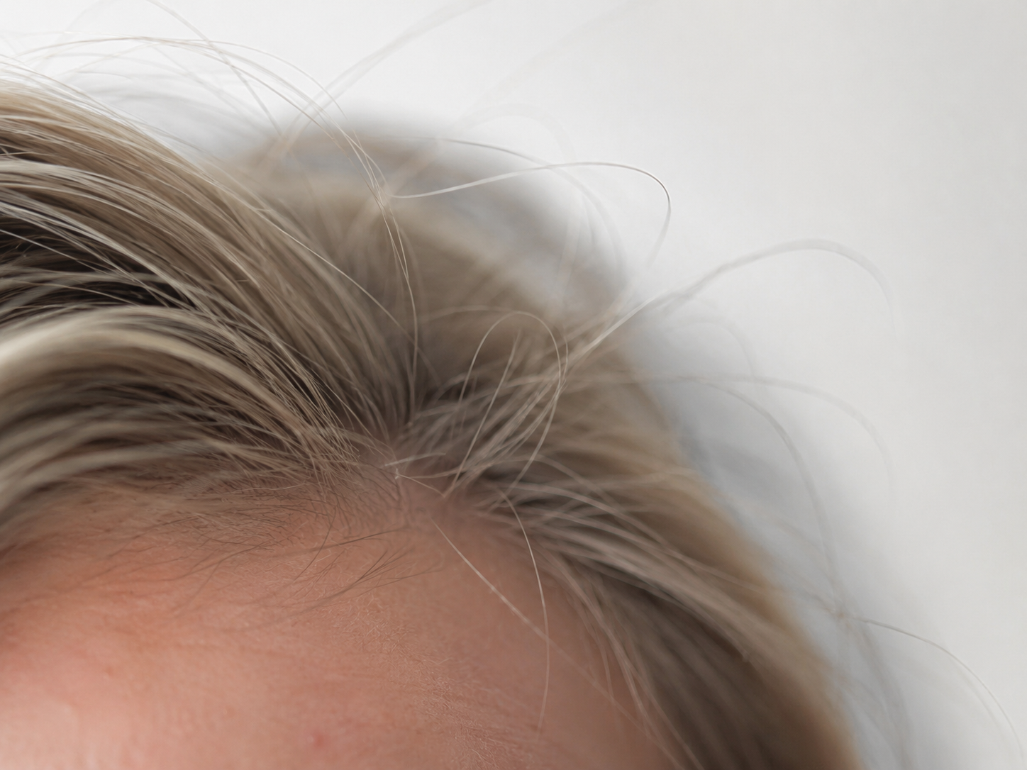 Portrait Mode ON — flyaway strands smeared into the background, halo along the skull.