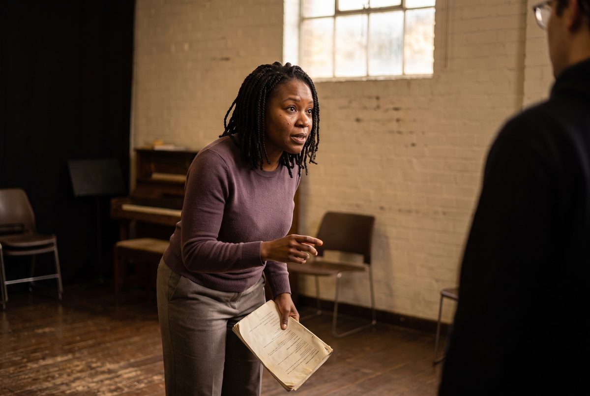 Two actors working a scene together in a rehearsal room