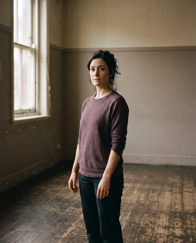 An actor standing in a rehearsal room, calm and ready to work