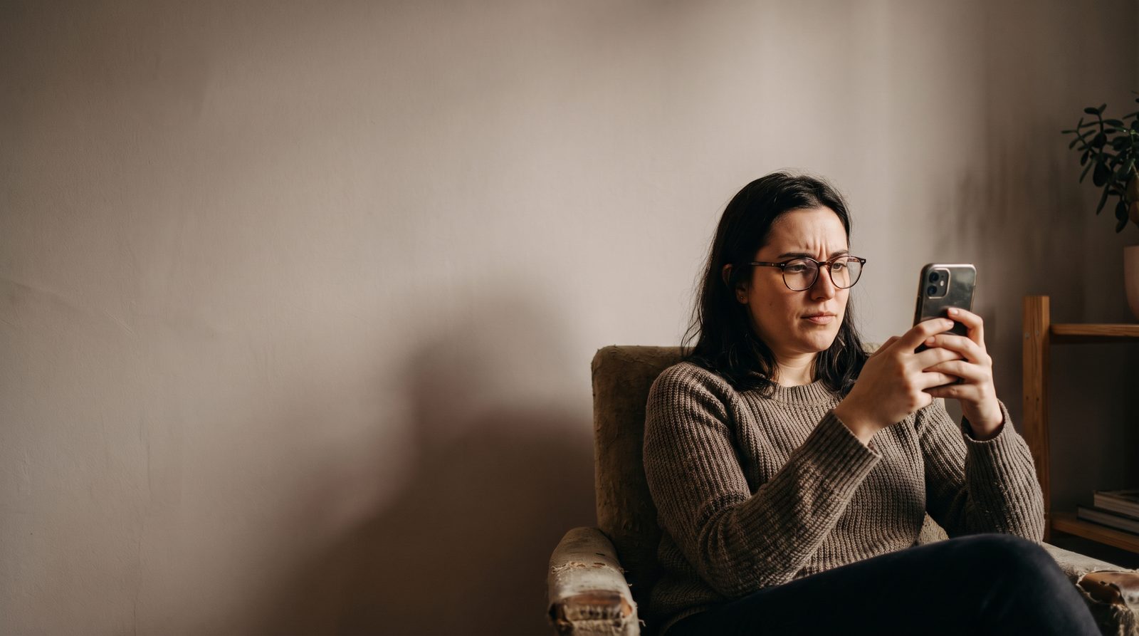 An actor looking at a phone screen showing a grid of generated portrait images