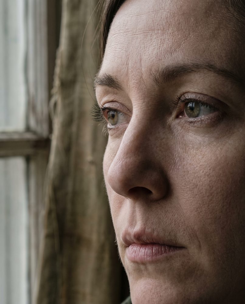 An extreme close-up of an actor's face, still and listening