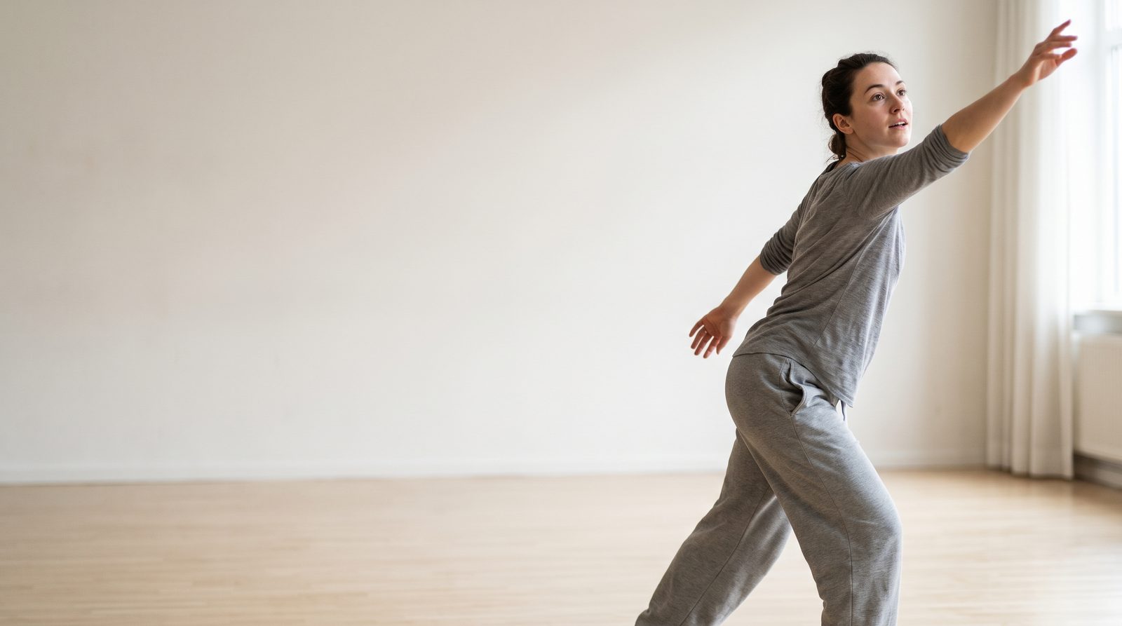 An actor in a studio reaching upward and outward with the whole body, mid-gesture
