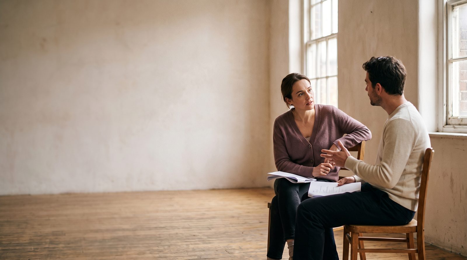 An actor listening closely to a scene partner in a rehearsal room