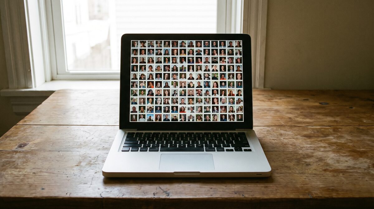 A laptop screen showing a dense grid of small portrait thumbnails