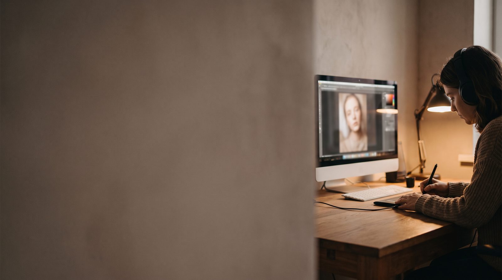 A retoucher working on a portrait photograph on a computer screen
