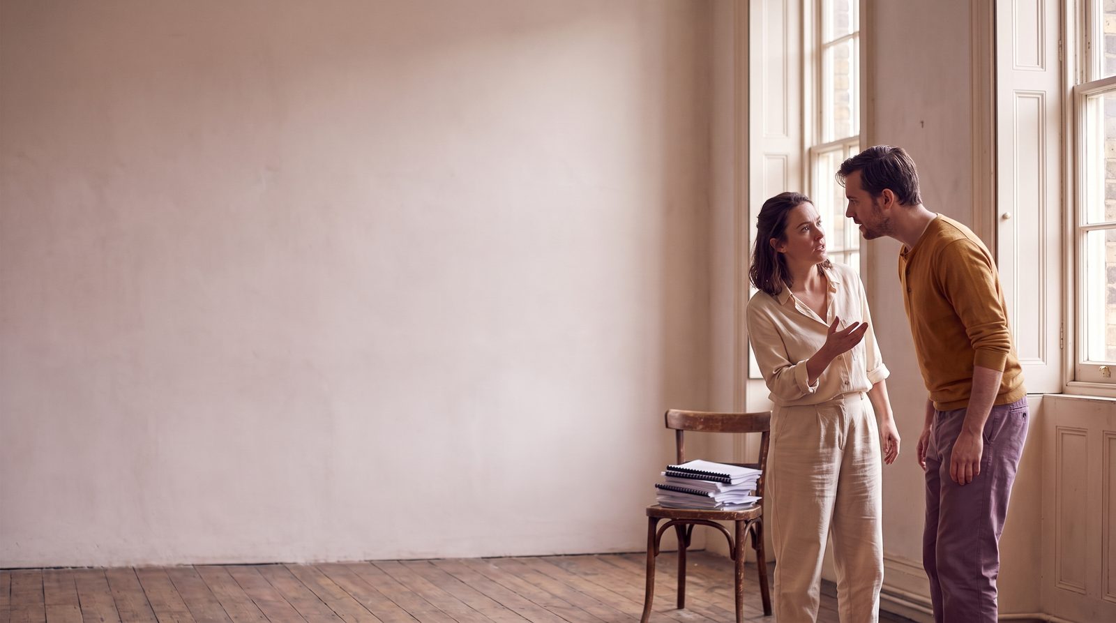 Two actors working through a scene on their feet in a rehearsal room