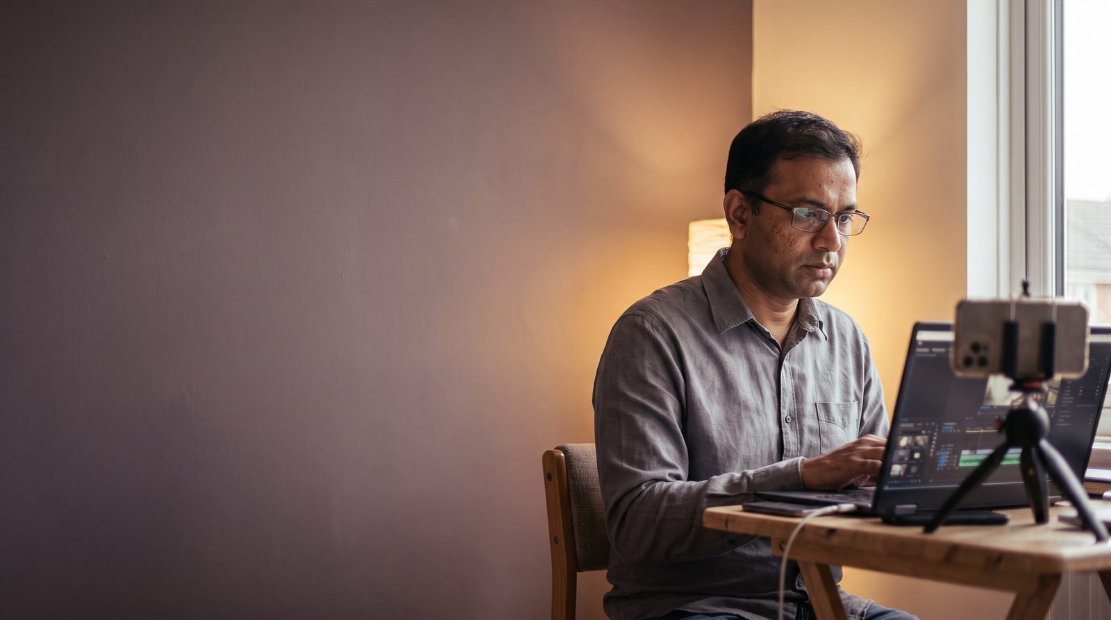 An actor trimming a self-tape clip on a laptop at home