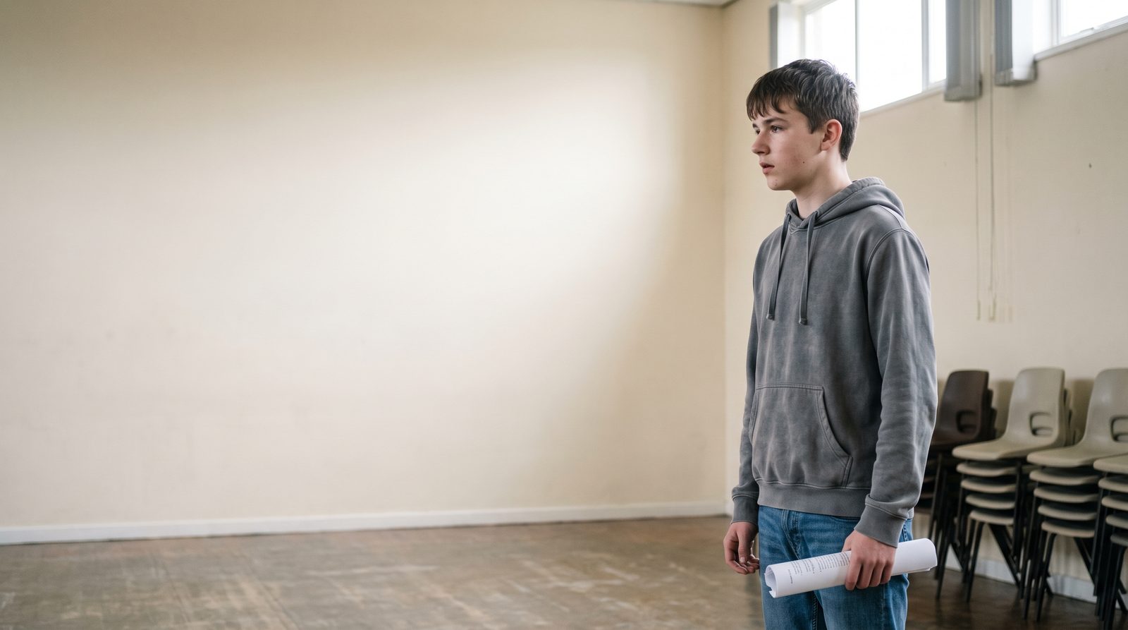 A teenager working in a youth theatre rehearsal in a school hall