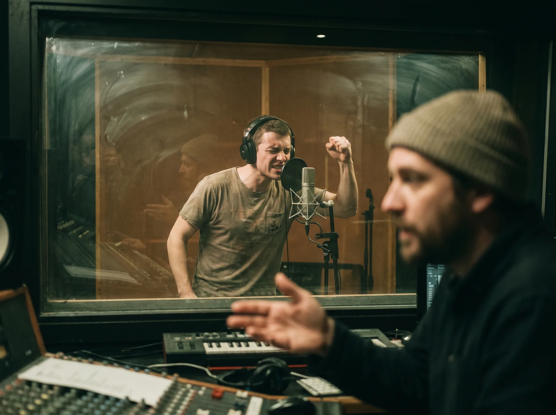 A voice actor performing a character line while a director listens