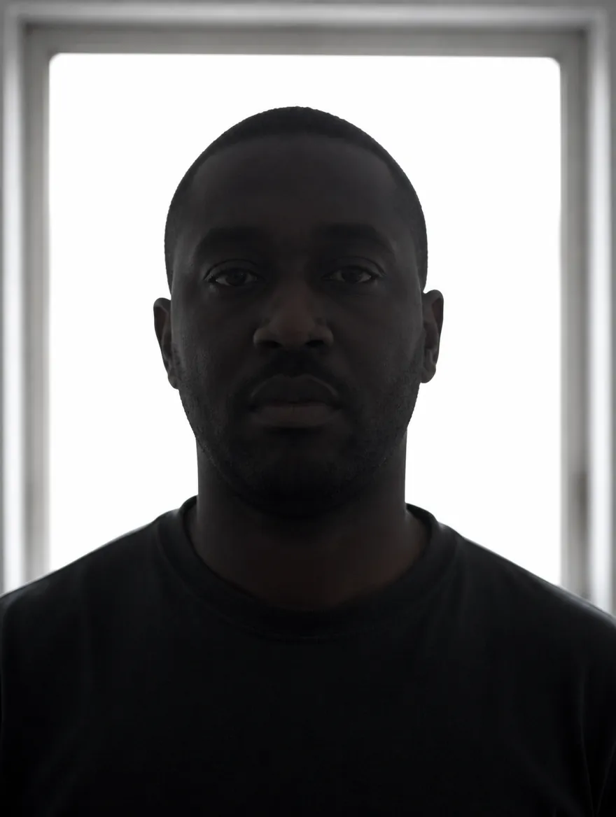 Actor lit only by a bright window behind him, face left dark and flat by the camera's auto-exposure